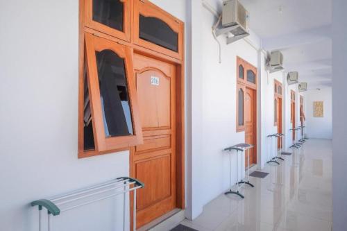 eine Reihe von Holztüren an der Seite eines Gebäudes in der Unterkunft Urbanview Syariah Wisma Nabil Solo in Lawean