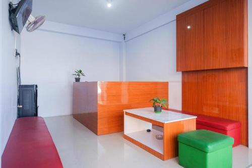 una habitación con una mesa y un taburete verde. en Urbanview Syariah Wisma Nabil Solo en Lawean