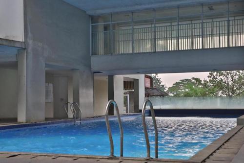 茂物的住宿－Buka Room Apartemen Bogor Valley，一座建筑物前带两个金属栏杆的游泳池