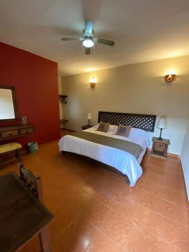 a bedroom with a large bed and a ceiling fan at San Sebastian in Comitán de Domínguez