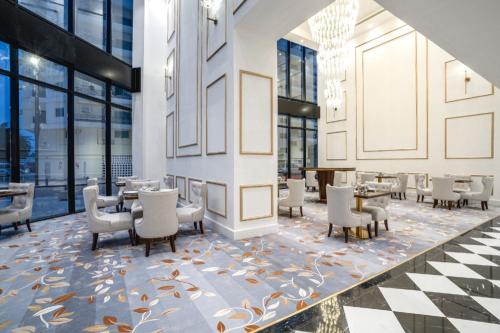 ein Restaurant mit Tischen und Stühlen und einem karierten Boden in der Unterkunft Royal sherao hotel فندق شراعوه الملكي in Doha