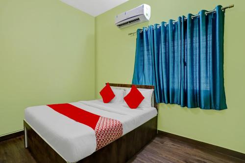 a bedroom with a bed with red and blue curtains at Flagship Hotel Pritesh Avenue in Nagpur
