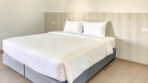 a large white bed with white sheets and pillows at น่าน ม่วนใจ Nan Muanjai Hotel in Pua