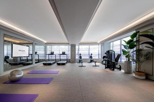 a gym with pilates equipment in a large room at 广州白云国际机场美居酒 店 in Huadu