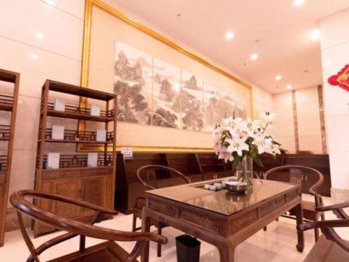 Heshan的住宿－Bashan Hotel，一间带桌椅和绘画的用餐室