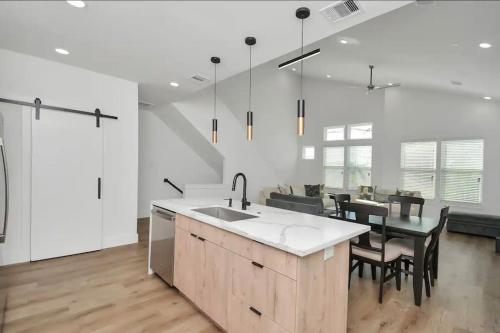 a kitchen with a sink and a table with chairs at 6 Mins to Dwtn /12 Mins to Rodeo in Houston