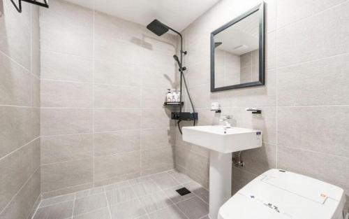 uma casa de banho com um lavatório, um WC e um espelho. em Wonju Bellino Hotel em Wonju