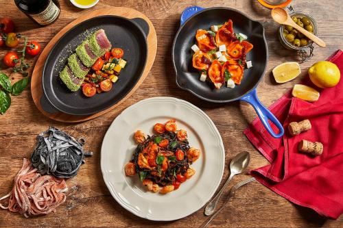 a table with two plates of food and a skillet at Shangri-La Jakarta in Jakarta
