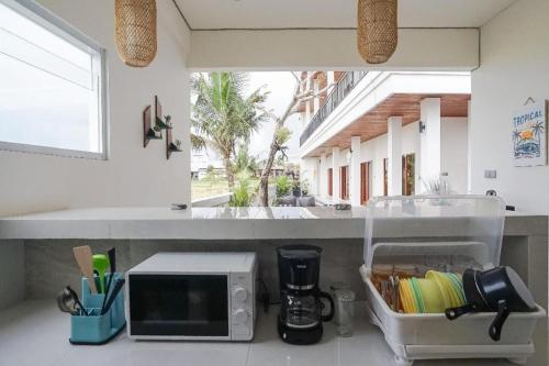 un bancone della cucina con forno a microonde su un piano di lavoro di Kerti Suite a Tanah Lot