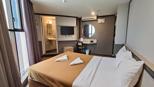 a bedroom with a bed with two napkins on it at Urban Inn, Jitra in Jitra