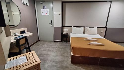 a bedroom with a bed and a sink and a mirror at Urban Inn, Jitra in Jitra