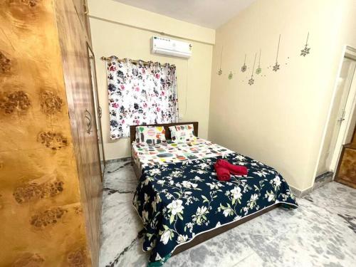 a small bedroom with a bed with a floral bedspread at Beautiful 3bhk at Hitechcity in Kondapur