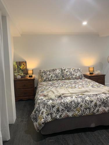 a bedroom with a bed and two night stands at Ocean Park Retreat in Yeppoon