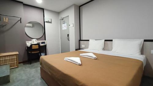 a bedroom with a large bed with two towels on it at Urban Inn, Jitra in Jitra