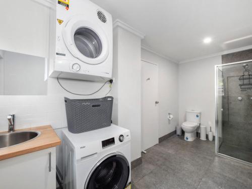 a bathroom with a washing machine and a sink at Ocean Park Motel & Holiday Apartments in Coffs Harbour