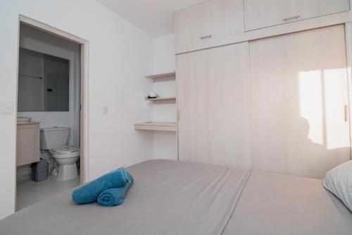 um quarto com uma cama com uma toalha azul em Apartamento El Colibri Cartagena en torre PRIMI em Cartagena das Índias