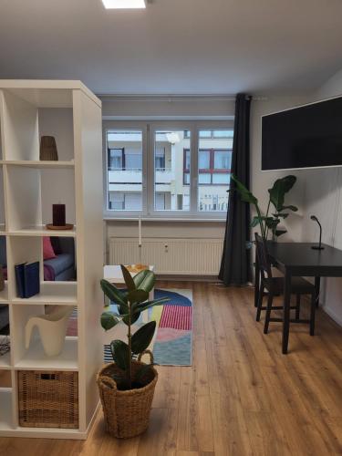 a living room with a table and a window at ALA Living Stadt-Schwärmer Apartment 10min zum Ulmer Münster & Ulmer Altstadt, WLAN & Arbeitsplatz in Neu Ulm