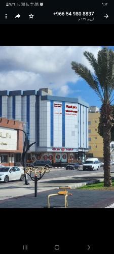 a building with a palm tree in front of a street at فندق حلم الحياه in Taif