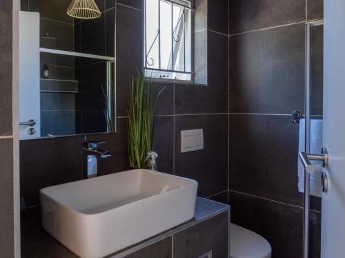 a bathroom with a tub and a toilet and a sink at Villa da Graca in Mossel Bay
