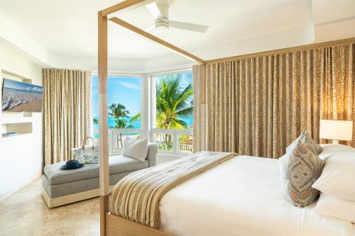 a bedroom with a bed and a view of the ocean at Grace Bay Club in Grace Bay