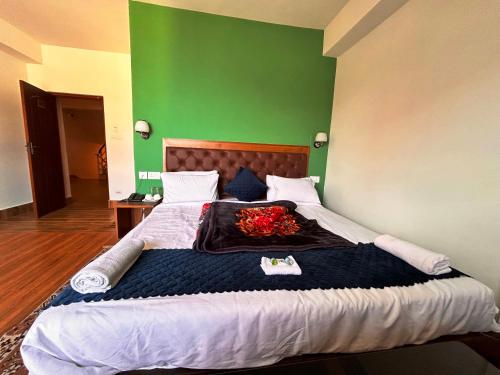 a bedroom with a large bed with a green wall at DISHA SILVER PEAK Hotel in Pelling