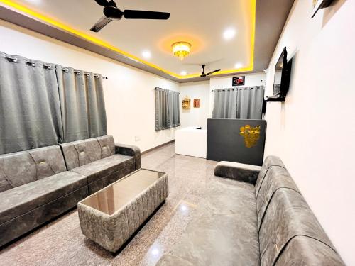 ein Wohnzimmer mit einem Sofa und einem TV in der Unterkunft Hotel Kutch Palace in Bhuj