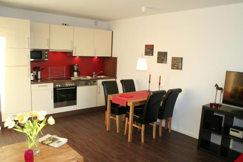 eine Küche und ein Esszimmer mit einem Tisch und Stühlen in der Unterkunft APARTHOTEL am Südkanal in Hamburg