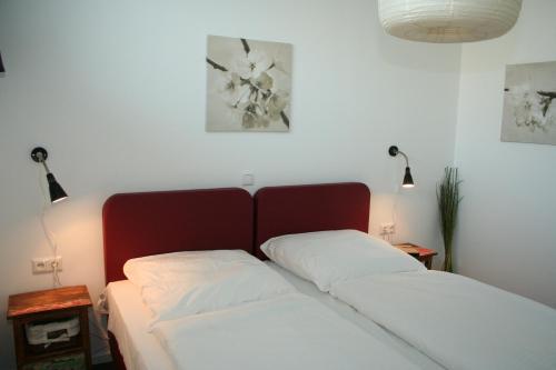 ein Bett mit zwei weißen Kissen in einem Zimmer in der Unterkunft APARTHOTEL am Südkanal in Hamburg