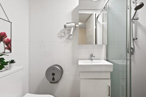 y baño blanco con lavabo y ducha. en Boutique Private Room in Chippendale Terrace room, en Sídney