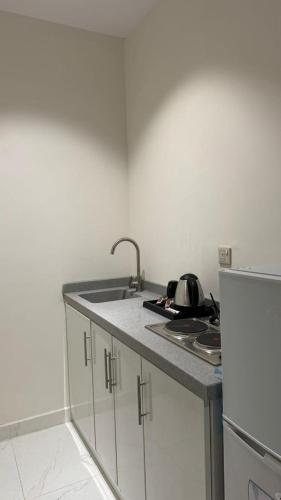 uma cozinha com um lavatório e uma bancada em شقة جميله بصالة وغرفة نوم وإدخال ذاتي em Al-Kharj