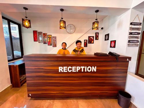 two men standing behind a bar at a restaurant at DISHA SILVER PEAK Hotel in Pelling
