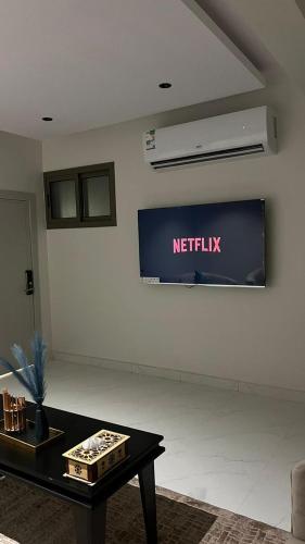 a living room with a netflix sign on the wall at شقة جديدة بصالة وغرفه نوم ودخول ذاتي مستقل in Al Kharj