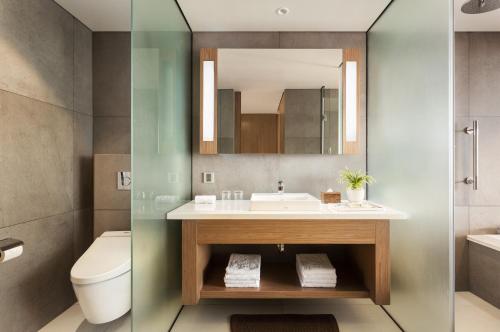 a bathroom with a sink and a toilet and a mirror at Hotel Emion Phnom Penh in Phnom Penh