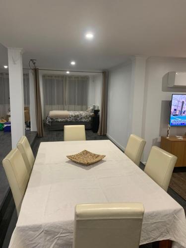 a dining room with a white table and chairs at Ocean Park Retreat in Yeppoon