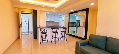 a living room with a couch and a kitchen at Kulai d'putra suites beside ioiMall near Airport and JPO in Kulai