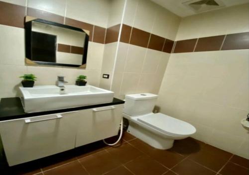 a bathroom with a white toilet and a sink at Horizon Hotel Tower One in Angeles