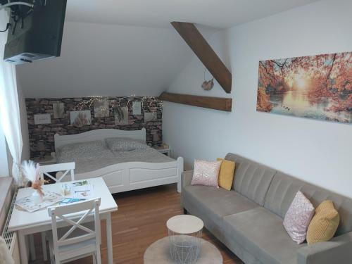 uma sala de estar com um sofá e uma cama em HomeW4 - Apartment Sonnenschein em Hoheneich