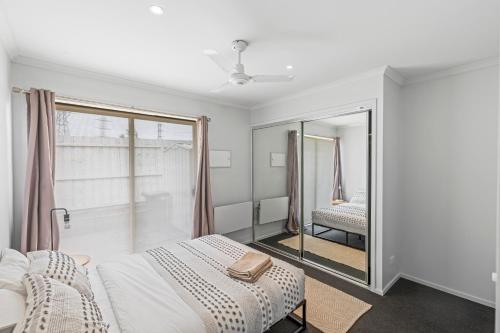 a white room with a bed and a mirror at Lovely Living in Lovely Banks