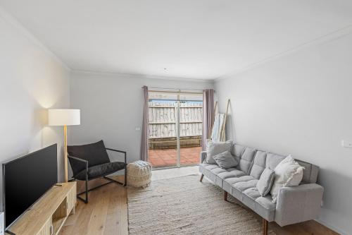 a living room with a couch and a tv at Lovely Living in Lovely Banks