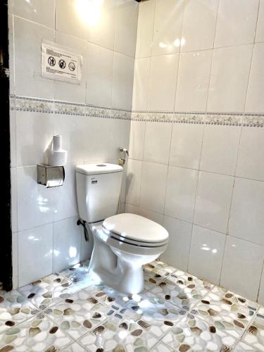 a bathroom with a white toilet in a room at Hometravel Mekong Can Tho in Can Tho