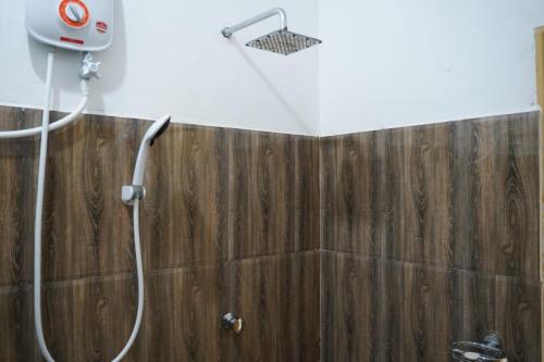 y baño con ducha y pared de madera. en Ali Adi Eco Lodge, en Sigiriya