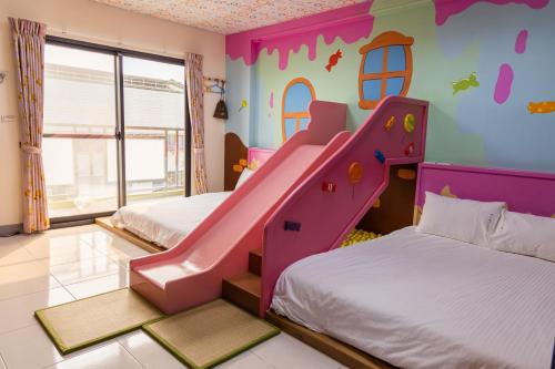 a kids room with two beds and a slide at 宜家莊親子民宿 in Donggang