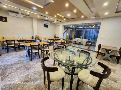 Rani Palace Hotel And Resort في كيشانجاره: مطعم فيه طاولات وكراسي في الغرفة