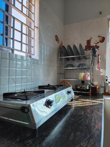 a kitchen with a stove top oven in a kitchen at Mahabs Beachview Homestay in Mahabalipuram