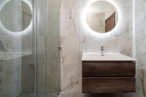 een badkamer met een wastafel en een spiegel bij Designer 2 bed 2 bath near sea in Il-Gżira