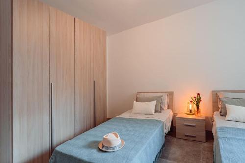 een slaapkamer met 2 bedden en een hoed erop bij Designer 2 bed 2 bath near sea in Il-Gżira