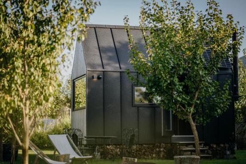 a tiny house with a black facade at AIVA Glamping in Partizánske