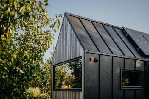 a black house with a black roof at AIVA Glamping in Partizánske