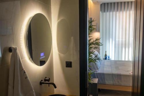 a bathroom with a sink and a mirror and a bed at Triple A - Stylish Seven On The Pedestrian - FREE Parking! in Athens