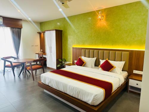 a bedroom with a bed and a table and a dining room at Mary Land Residency in Meenangadi